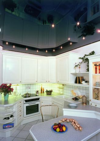 Como no caso da placa de gesso, os tetos tensos para a cozinha ficam muito mais impressionantes com uma iluminação bem montada.