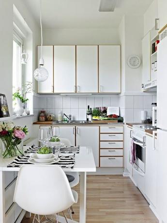 O azulejo branco como um backsplash de cozinha combina com o acabamento de madeira do fone de ouvido e do piso