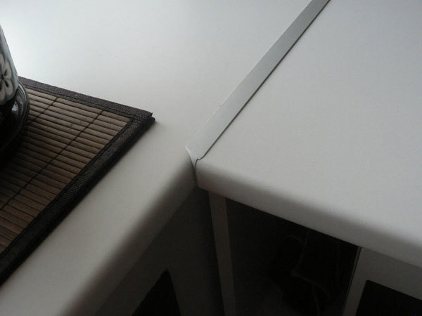 A lacuna entre as duas metades do tampo da mesa é escondida por uma tira de metal