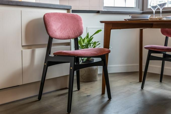 Acomodar a mesa de jantar convidar quatro cadeiras feitas de contraplacado de bétula revestido com um esmalte resistente à umidade, com costas e assentos estofados em rica tonalidade rosa.