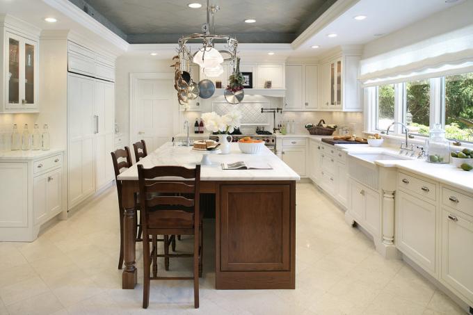 Os azulejos têm acabamento em cinza para realçar a cozinha branca, enquanto o drywall branco combina com o estilo geral da sala.