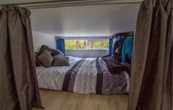 Mini-quarto com uma cama grande.