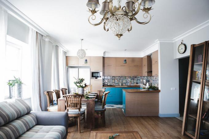 Paredes claras na sala de estar e azulejos na cozinha do mesmo esquema de cores formam um bom conjunto