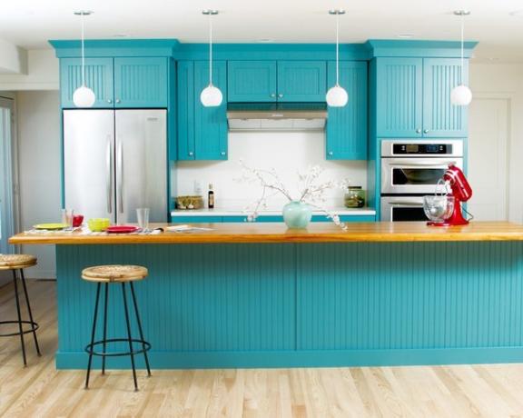 Cozinha definida em cor turquesa combinada com paredes e piso claros