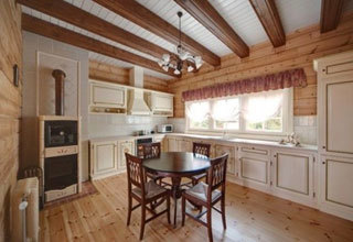 Cozinha de estilo provençal com piso de madeira e tetos com vigas.