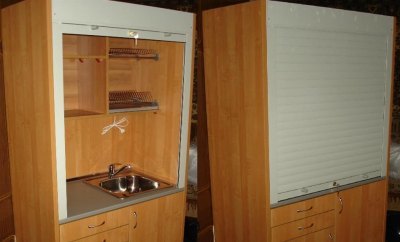 Mini cozinha em um armário com persianas em vez de portas
